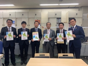 森田町長と国土交通省の方々5名が冊子を持ち記念撮影をしている写真
