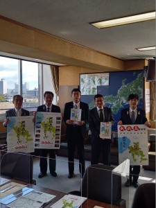 ポスターやパンフレットをそれぞれ持ち記念撮影をしている森田町長、吉村富田林市長、小林近畿地方整備局道路部長、東川近畿地方整備局長、島田河内長野市長の写真