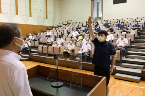 演台に立っている市長の向かい側に右手を上にあげた男性が立ち、宣誓を行っている様子の写真
