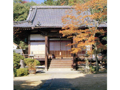 本堂の右手前にオレンジに色づいた紅葉がある法華寺の写真