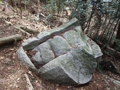 上部が四角形で四段の板のように溝があり、下は丸みを帯びて、一部割れているいる久米の岩橋の写真