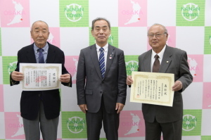 中央に森田町長が立ち、町長の両側に賞状を持った古川区長会会長、松井老人会会長が立ち記念撮影をしている写真