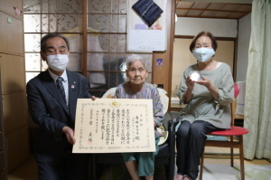 森田町長が賞状を持ち寺田さんと寺田さんのご家族と記念撮影をしている写真