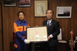 久門末男さんと森田町長が一緒に額に入った賞状を持ち記念撮影をしている写真