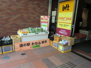 入口横の壁際に、台に並べられた野菜や、ケースに入った野菜が並べて置かれている写真