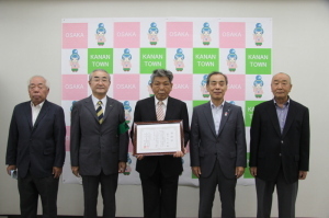 廣谷区長表彰式にて中央の男性が賞状を持ち、両脇にそれぞれ2名ずつ関係者の男性が並び記念撮影をしている写真