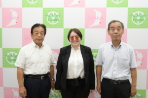 笑顔のブリタニーさんを中心に新田教育長、森田町長3人で記念撮影をしている写真