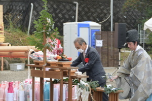 式典にて祭壇の前で玉串を持っている神主、その横で森田市長がの祈念している写真