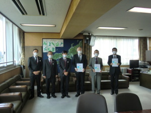 スーツを着た男性6名が横一列に並んで記念撮影をしている写真