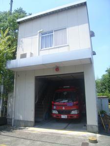 白い2階建ての石川分団の1階の車庫に消防車が駐車されている写真
