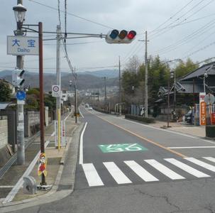 信号機の側の路面に「ゾーン30」と書かれている道路の写真